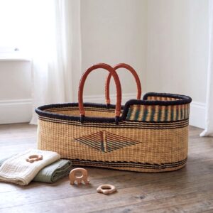 Natural handwoven Moses baby basket with leather carry handles.