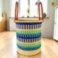 Open laundry basket with a woven pattern and stitched leather handles