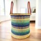Open Bolga laundry basket with a patterned weave and leather handle detail