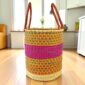 Open weave laundry basket with a patterned design and leather carry handles