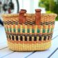 woven bicycle basket with leather straps in natural, green, and orange colours