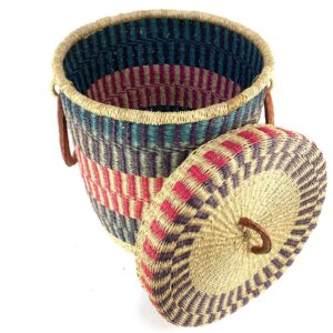 Diagonal side view of an Laundry African basket, showing its depth, top lid, vibrant woven patterns and leather handle detail