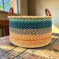Large Bolga hamper basket photographed in a neutral home setting.