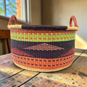 Large elephant grass basket filled with blankets and homewares.