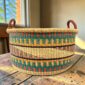 Large elephant grass basket filled with blankets and homewares.