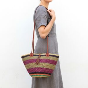 Handcrafted African Bolga shoulder bag with striped woven design, leather handles and tassel accent.