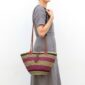 Handcrafted African Bolga shoulder bag with striped woven design, leather handles and tassel accent.