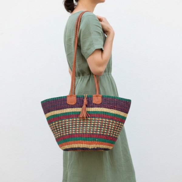 Artisan Bolga basket shoulder bag with genuine leather straps and decorative tassel detail.