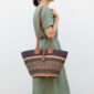Artisan Bolga basket shoulder bag with genuine leather straps and decorative tassel detail.