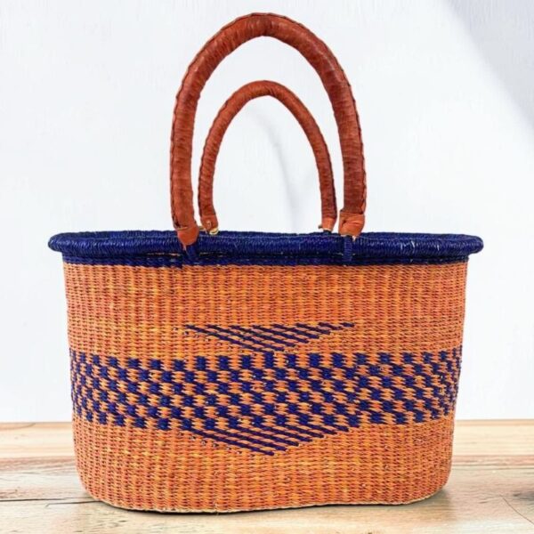 Oval-Basket-465-tangelo (1)-bolgatana Oval woven basket with leather handles photographed against a neutral background.