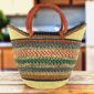 Classic market basket with an open weave and multicolour patterned bands and leather-wrapped handles
