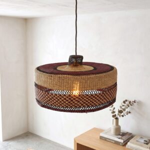 Woven bolga lampshade hanging beside a plant, burgundy and black stripes over natural straw