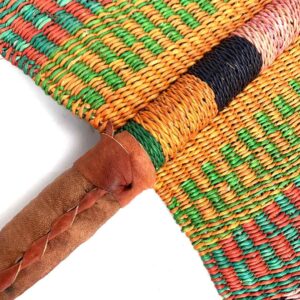 Close-up of the weave and leather handle on the orange and green Bolga fan