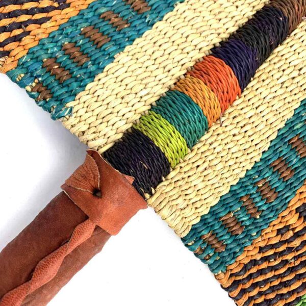 bashiri-fan-s1-265-breezy-bolga-fan-elephant-grass-2 Close-up of the weave and leather handle on the teal and pink Bolga fan