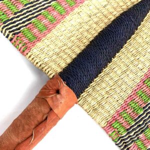 Close-up of the weave and leather handle on the pink and natural Bolga fan