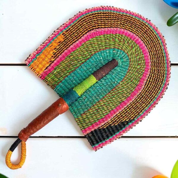 Woven Bolga hand fan in pink, olive and teal with a leather-wrapped handle