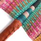 Close-up of the weave and leather handle on the pink, teal and orange Bolga fan