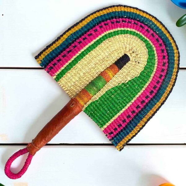 Woven Bolga hand fan in green and pink with a leather-wrapped handle