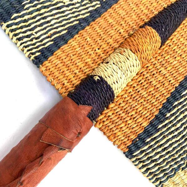 bashiri-fan-s1-277-atmosphere-bolga-fan-elephant-grass-2 Close-up of the weave and leather handle on the orange and black Bolga fan