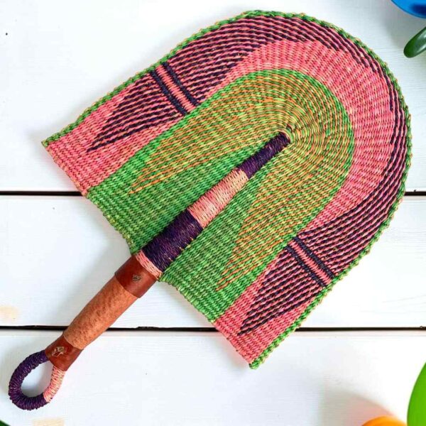 Woven Bolga hand fan in pink and green with a leather-wrapped handle