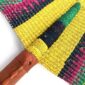 Close-up of the weave and leather handle on the yellow and green Bolga fan