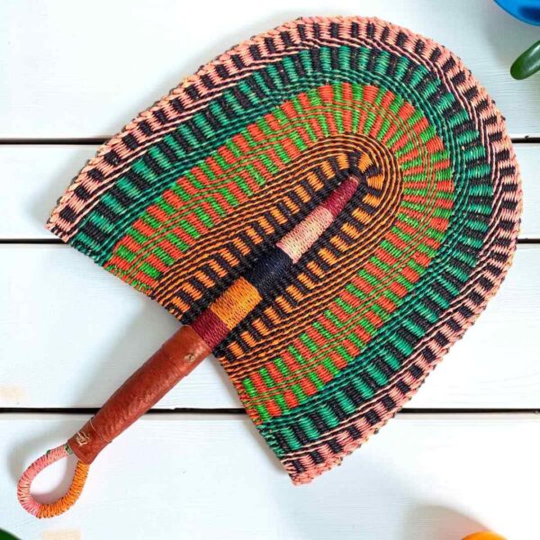 Woven Bolga hand fan in green and orange with a leather-wrapped handle