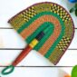 Woven Bolga hand fan in purple and green with a leather-wrapped handle
