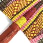 Close-up of the weave and leather handle on the pink and orange Bolga fan