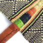 Close-up of the weave and leather handle on the black and orange Bolga fan