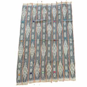 Full view of the faded indigo cotton cloth with pale diamond lattice motifs on a white background