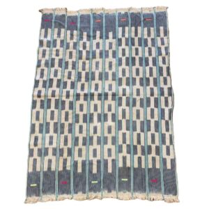 bashiri-indigo-cotton-242-keta-handwoven-african-textile-2 Full view of the pale cotton cloth with a stepped pattern of indigo blocks on a white background