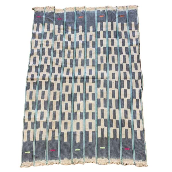 bashiri-indigo-cotton-242-keta-handwoven-african-textile-2 Full view of the pale cotton cloth with a stepped pattern of indigo blocks on a white background