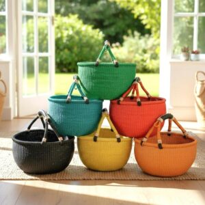 Large round Bolga baskets in a range of solid colours including green, teal, red, yellow, orange and black, with leather handles, styled indoors
