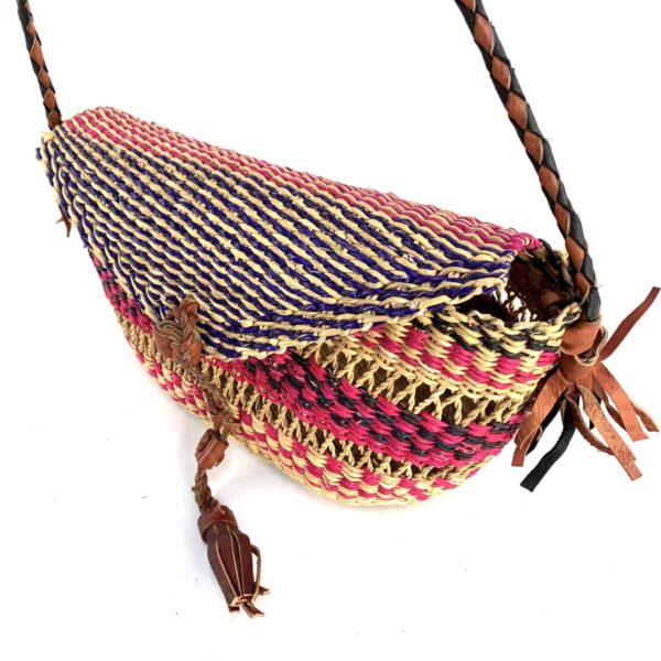 bashiri-mini-shoulder-bag-002-she-purple-pink-african-shoulder-bag-woven-3 Close-up of the woven flap and leather toggle on the purple and pink mini Bolga shoulder bag