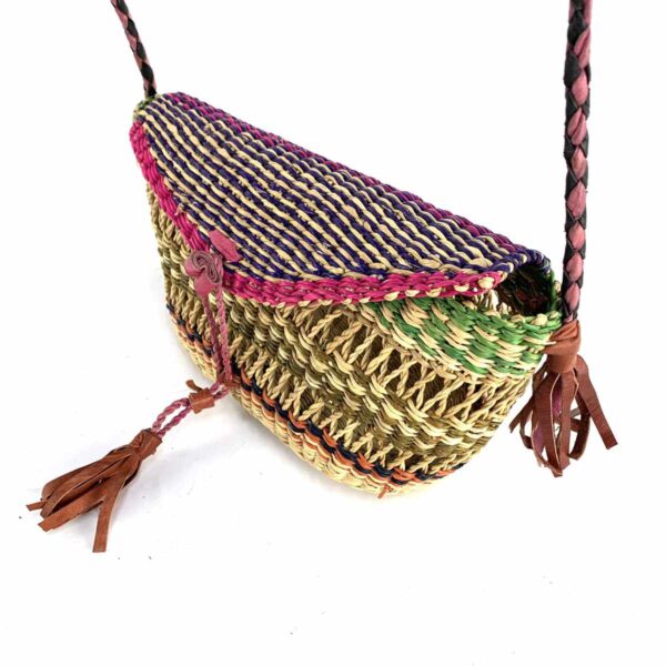 bashiri-mini-shoulder-bag-004-wendy-purple-green-woven-crossbody-bag-bolga-3 Close-up of the woven flap and leather toggle on the purple, pink, and green mini Bolga shoulder bag