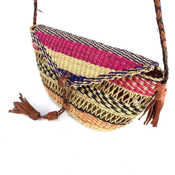 bashiri-mini-shoulder-bag-006-fizzy-pink-orange-african-shoulder-bag-woven-3 Close-up of the woven flap and leather toggle on the pink, black, and orange mini Bolga shoulder bag