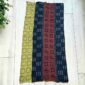 Medium patchwork mudcloth with chevron, dot and flower motifs, laid on a timber surface with green leaves
