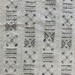 Close-up of the light mudcloth with columns of dark crosses and cowrie shapes