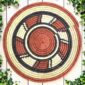 Woven raffia rust, black and natural Burkina platter with a wheel pattern, on white timber with greenery