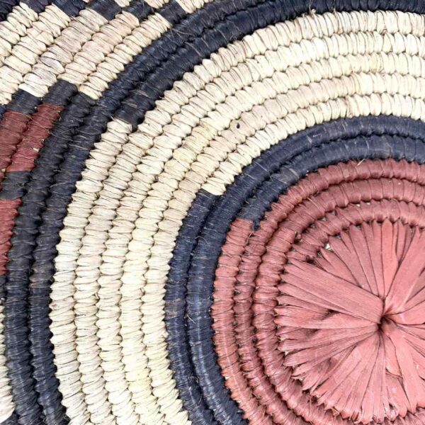 bashiri-placemat-179-radiance-african-platter-raffia-2 Close-up of the coiled raffia weave and centre of the rust, black and natural Burkina platter with a swirl pattern