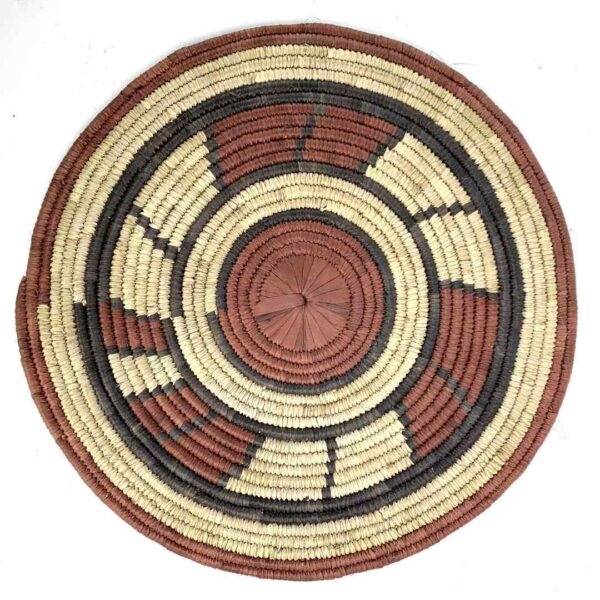 bashiri-placemat-180-blossom-woven-raffia-platter-3 Full view of the rust, black and natural Burkina platter with a block pattern on a white background