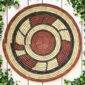 Woven raffia rust, black and natural Burkina platter with a block pattern, on white timber with greenery