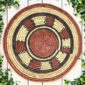 Woven raffia rust, black and natural Burkina platter with a ring pattern, on white timber with greenery