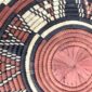 Close-up of the coiled raffia weave and centre of the rust, black and natural Burkina platter with a starburst pattern
