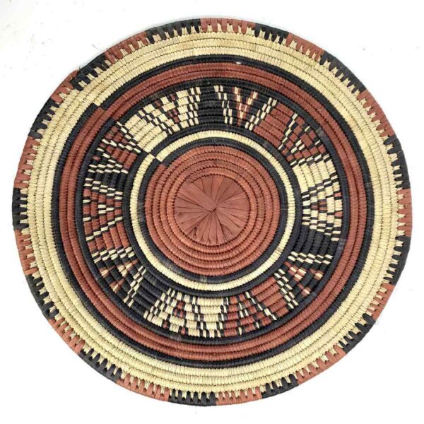 bashiri-placemat-182-sunbeam-burkina-platter-woven-3 Full view of the rust, black and natural Burkina platter with a starburst pattern on a white background