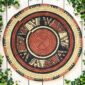 Woven raffia rust, black and natural Burkina platter with a starburst pattern, on white timber with greenery