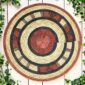 Woven raffia rust, black and natural Burkina platter with a concentric pattern, on white timber with greenery