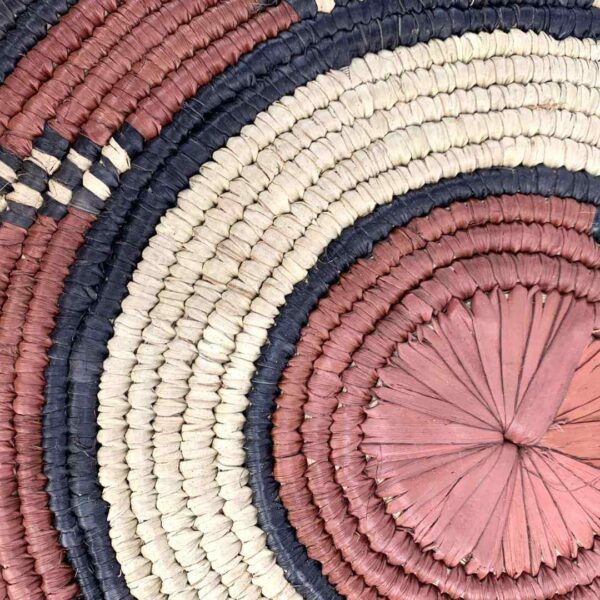 bashiri-placemat-184-delight-woven-raffia-platter-2 Close-up of the coiled raffia weave and centre of the rust, black and natural Burkina platter with a hook pattern