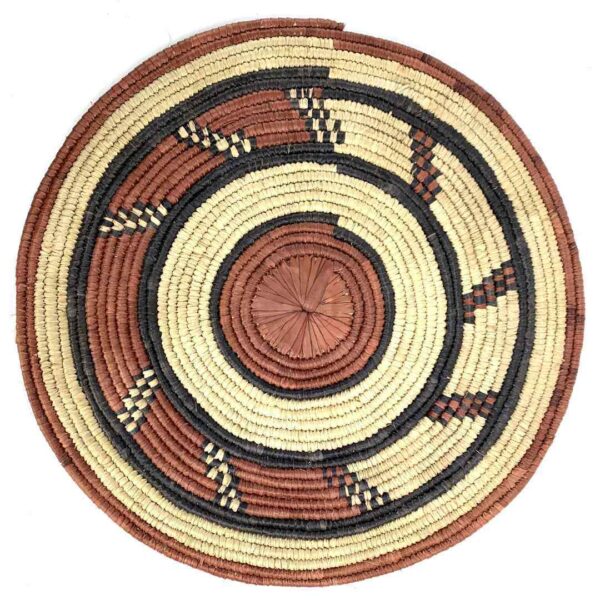 bashiri-placemat-184-delight-woven-raffia-platter-3 Full view of the rust, black and natural Burkina platter with a hook pattern on a white background
