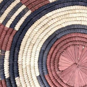 bashiri-placemat-185-tranquil-burkina-platter-handwoven-2 Close-up of the coiled raffia weave and centre of the rust, black and natural Burkina platter with a band pattern